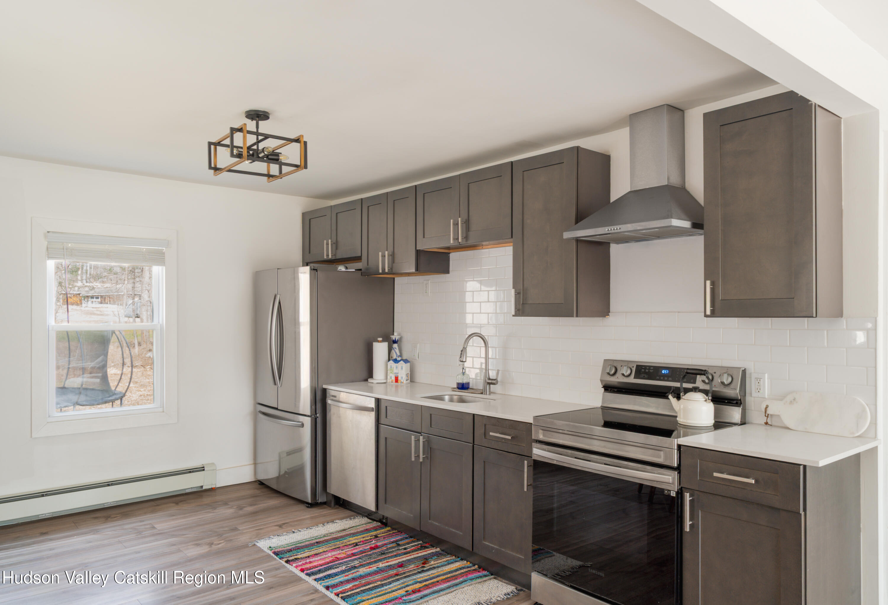 713 Oak Ridge Road Ellenville, NY 12428 - Photo 12 of 53 a kitchen with stainless steel appliances a sink a stove a refrigerator cabinets and a window