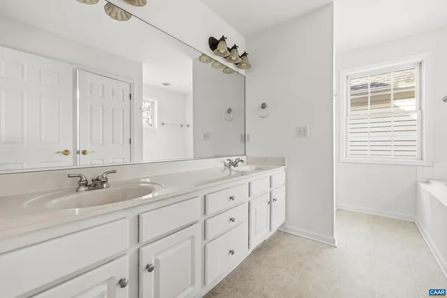 a bathroom with double sink and a mirror