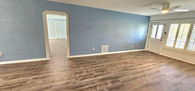 a view of a bedroom with wooden floor and furniture
