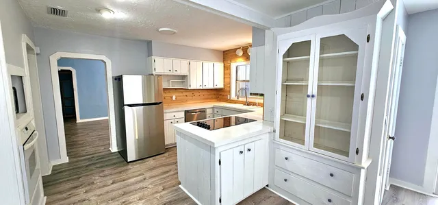a kitchen with white cabinets and refrigerator