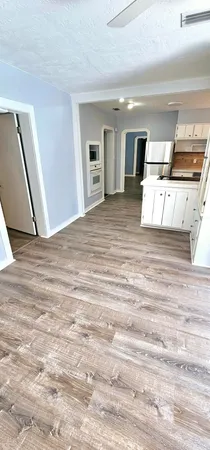 a view of a bedroom with wooden floor and kitchen