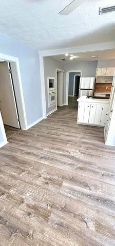 a view of a bedroom with wooden floor and kitchen