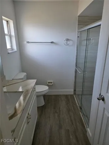 a bathroom with a granite countertop toilet and a sink