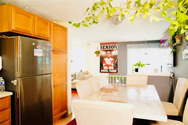 a view of a kitchen with stainless steel appliances wooden floor and a refrigerator