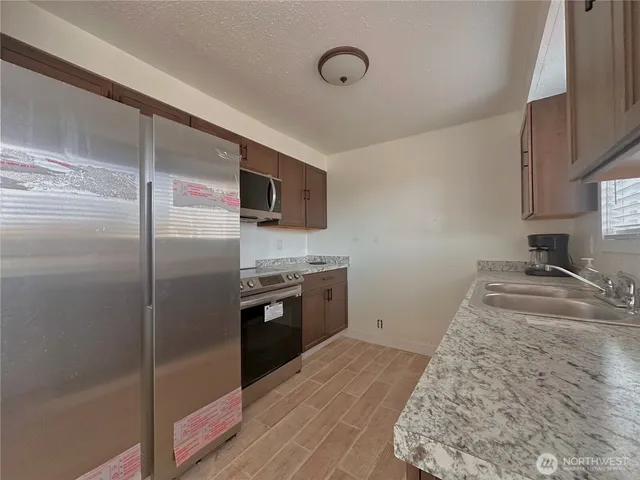 a kitchen with a refrigerator sink and stove