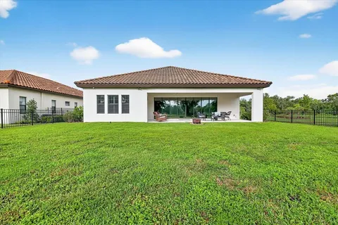 a aerial view of a house with a yard and large trees