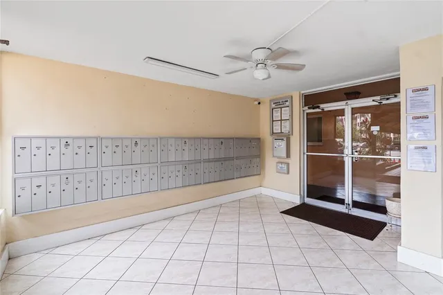 a view of an empty room with window and chandelier fan