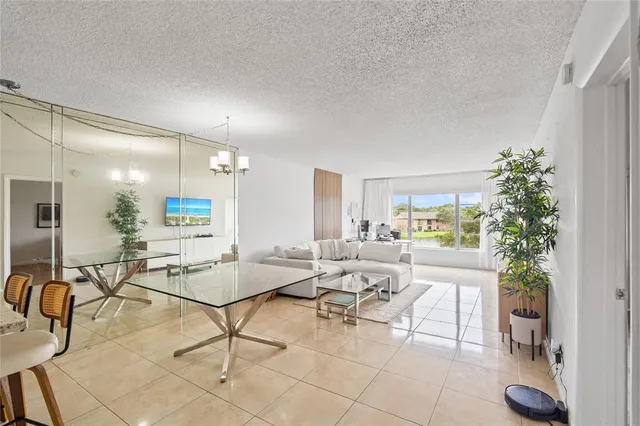a living room with patio furniture and a potted plant