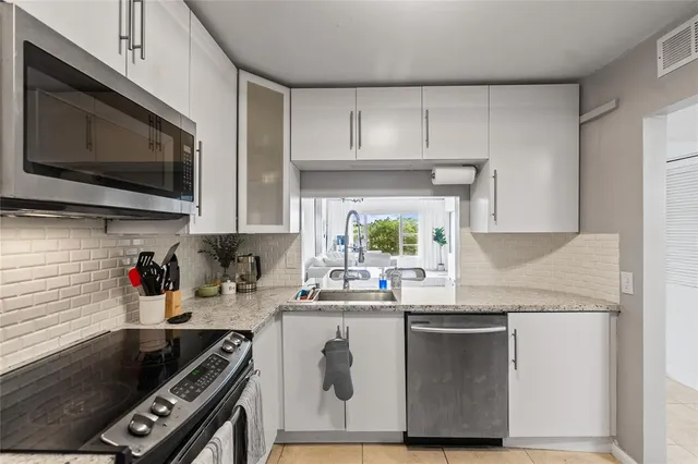 a kitchen with stainless steel appliances a sink a stove a microwave and cabinets
