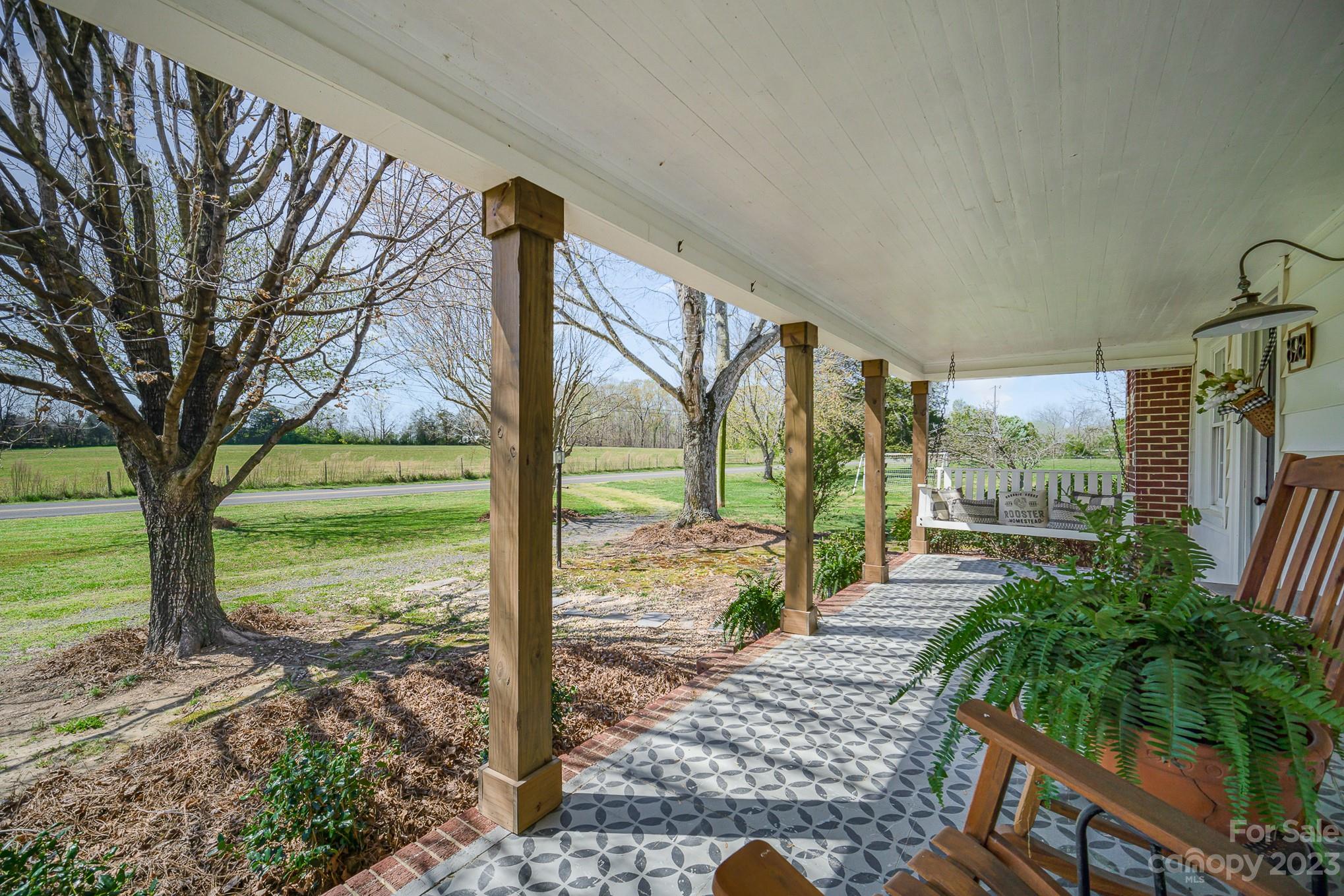 898 Hilltop Road Oakboro, NC 28129 - Photo 1 of 34 a view of a porch with furniture and garden