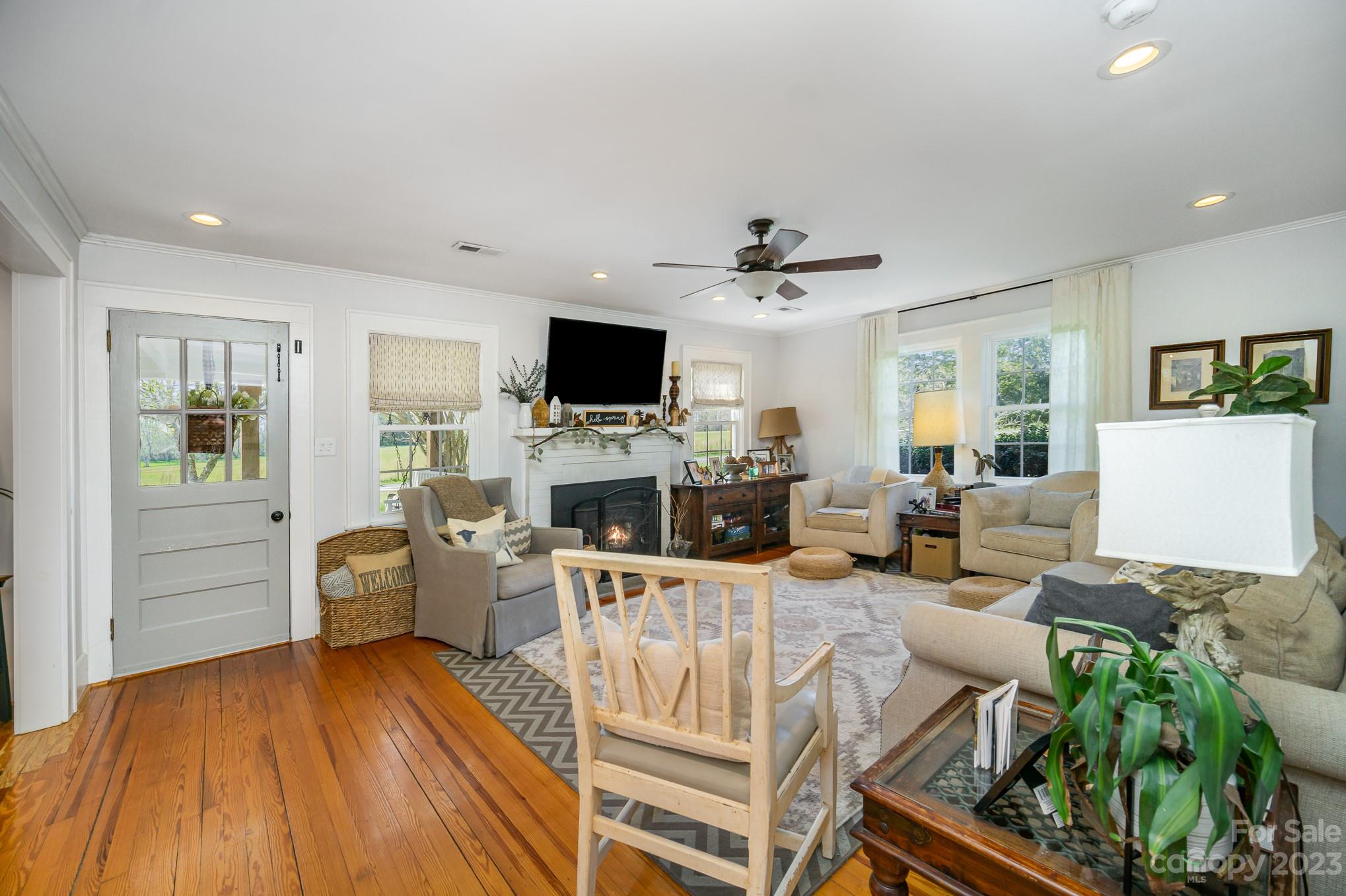 898 Hilltop Road Oakboro, NC 28129 - Photo 16 of 34 a living room with furniture a fireplace and a flat screen tv