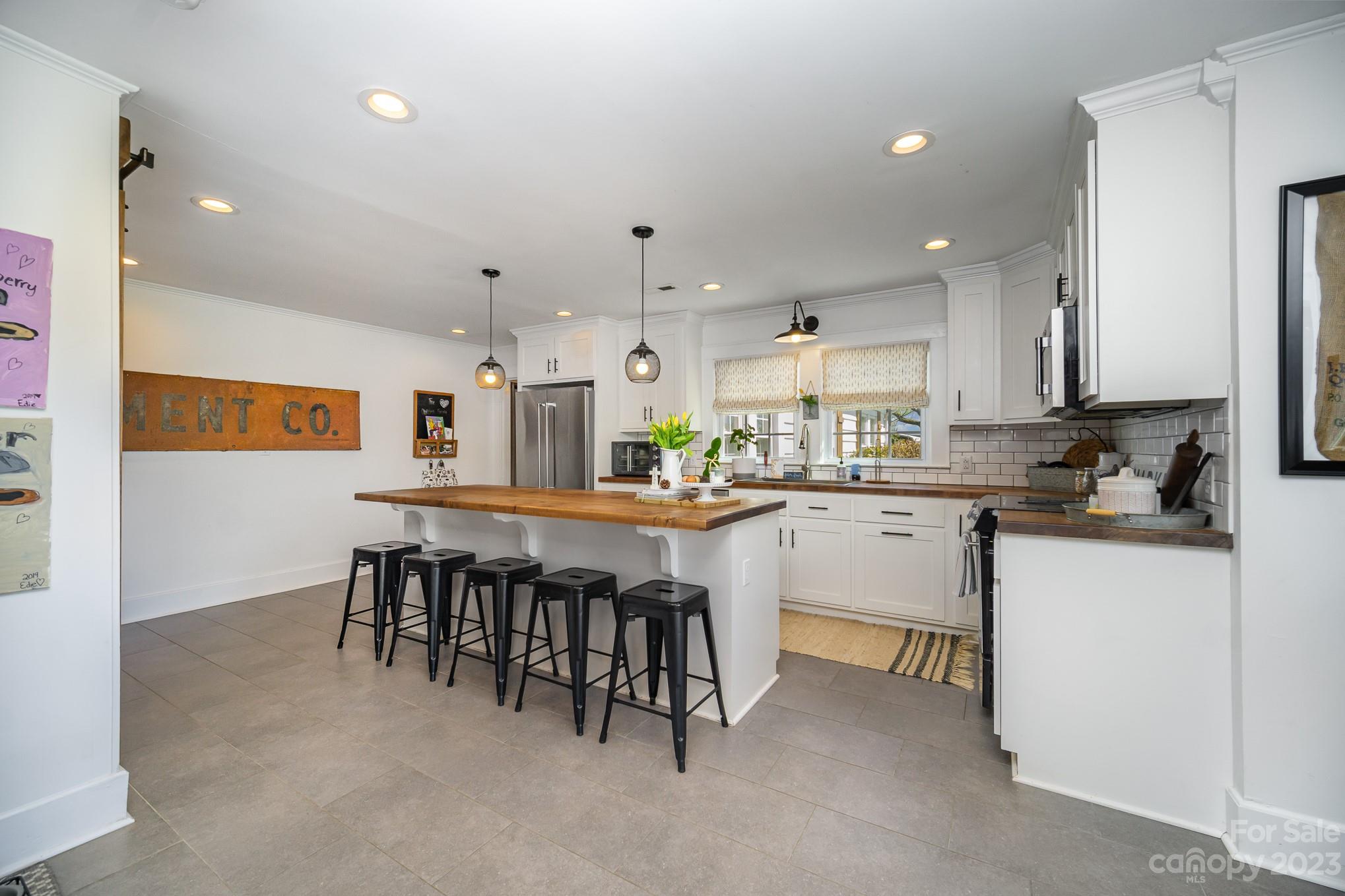 898 Hilltop Road Oakboro, NC 28129 - Photo 20 of 34 a kitchen with white cabinets and chairs