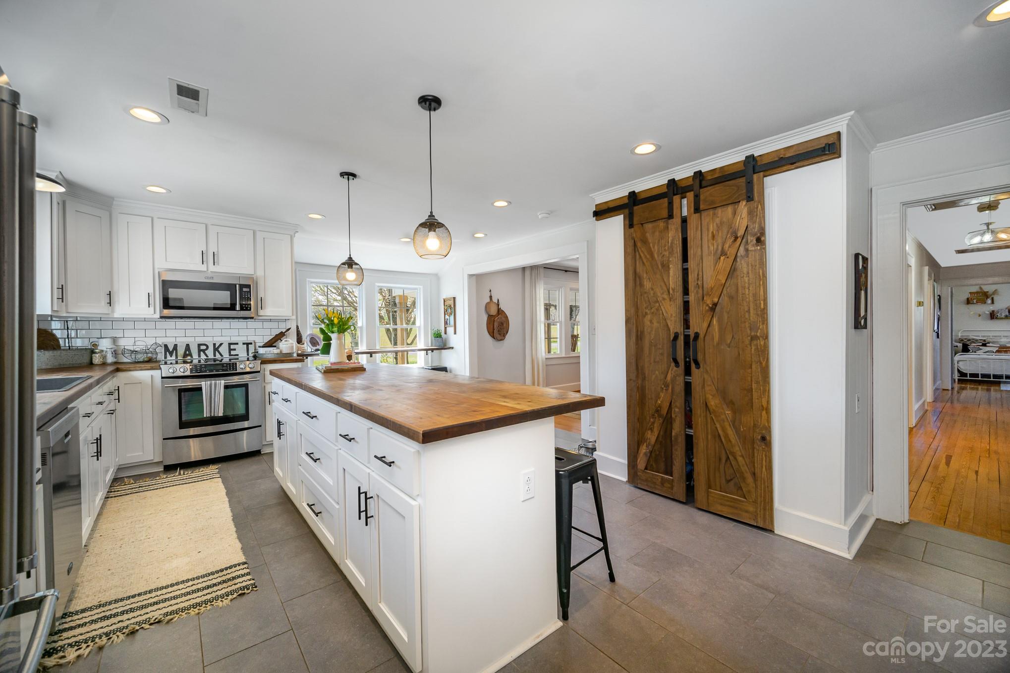 898 Hilltop Road Oakboro, NC 28129 - Photo 22 of 34 a kitchen with stainless steel appliances granite countertop a refrigerator a sink and a stove