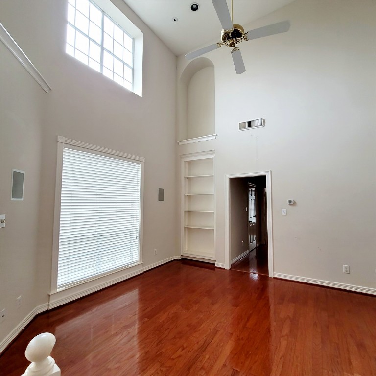 1526 Nevada Street Houston, TX 77006 - Photo 17 of 38 an empty room with wooden floor chandelier fan and windows