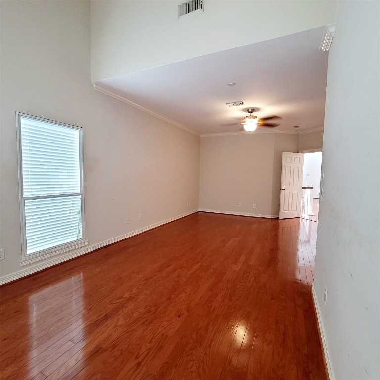 1526 Nevada Street Houston, TX 77006 - Photo 21 of 38 an empty room with wooden floor chandelier fan and windows
