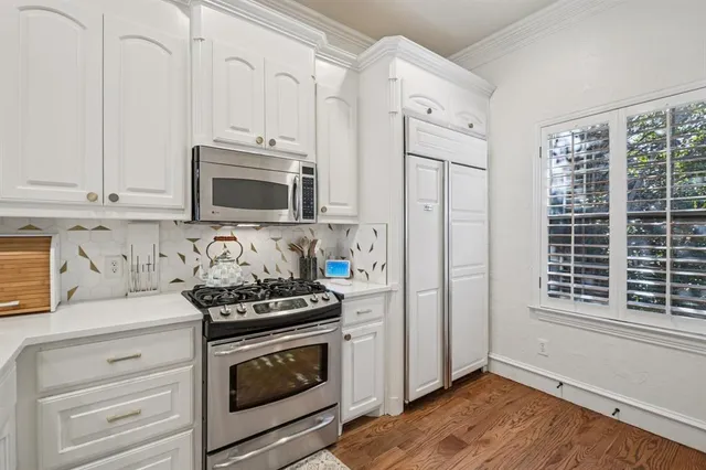 a kitchen with granite countertop white cabinets stainless steel appliances and sink