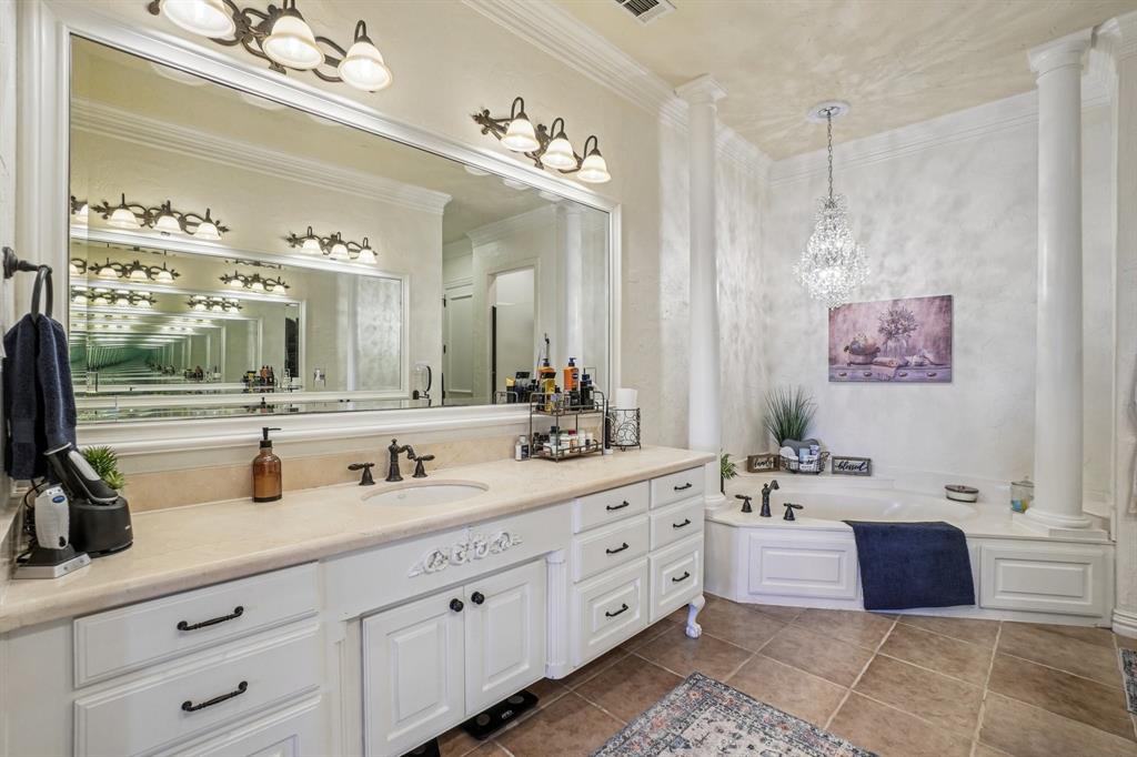 612 Rockingham Drive Irving, TX 75063 - Photo 31 of 39 a bathroom with a double vanity sink a mirror and a bathtub