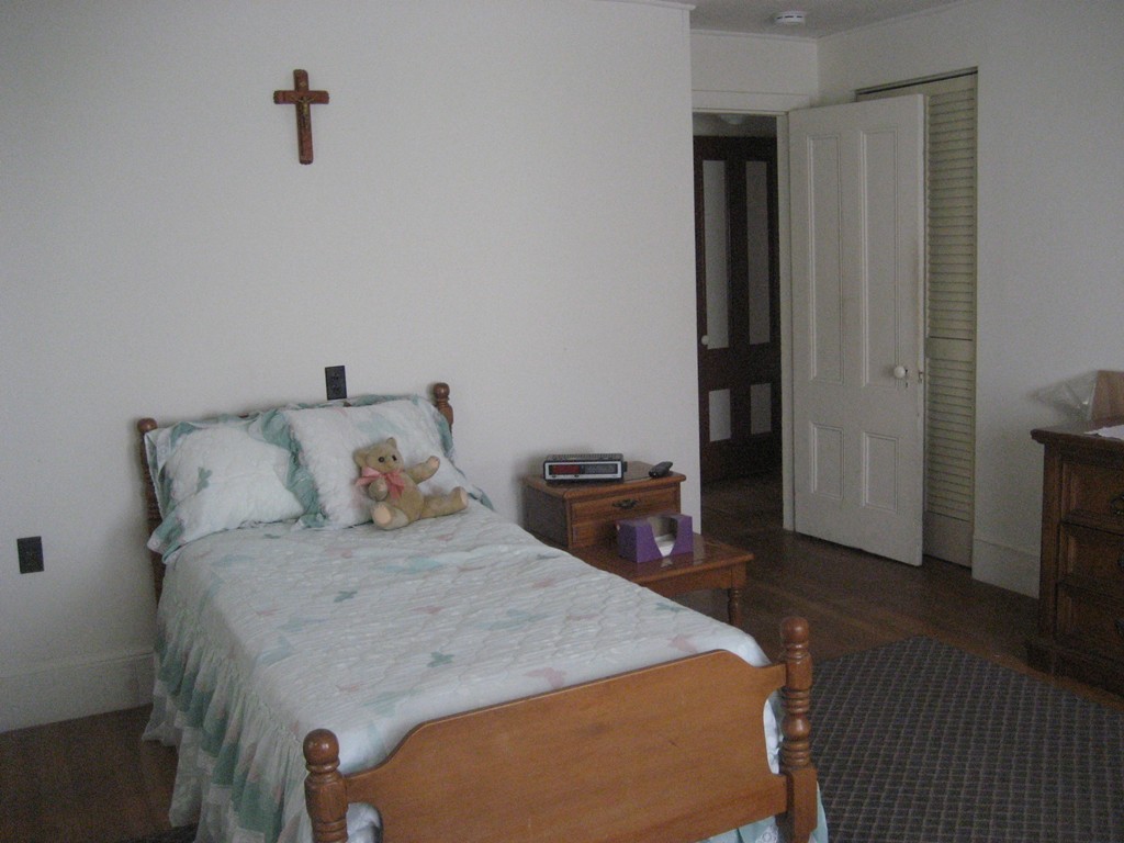 11 Clinton Street Everett, MA 02149 - Photo 17 of 25 a bed sitting in a bedroom next to a window with wooden floor