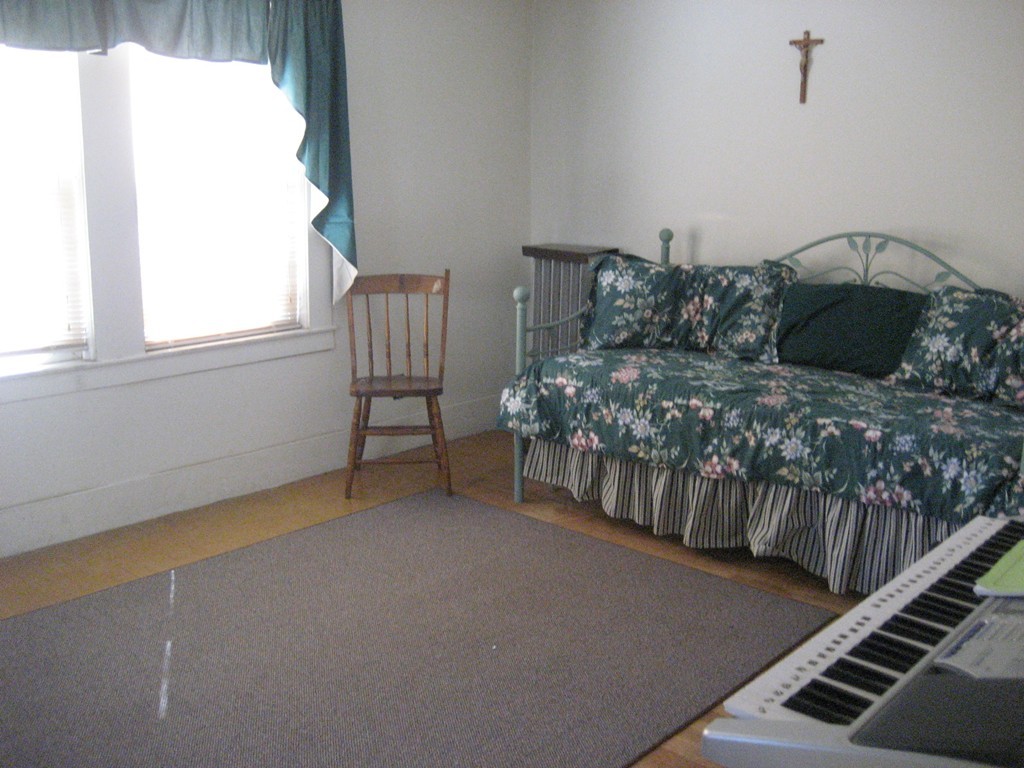 11 Clinton Street Everett, MA 02149 - Photo 19 of 25 a bed sitting in a bedroom next to a window