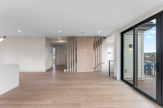 a view of a hallway with wooden floor and windows