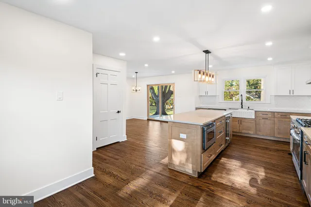 a kitchen with stainless steel appliances granite countertop a sink a stove and a wooden floors