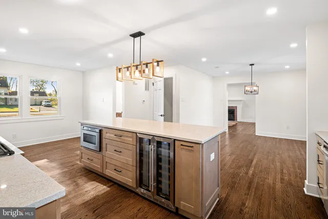 a kitchen with stainless steel appliances granite countertop a refrigerator a sink dishwasher a stove and white cabinets with wooden floor