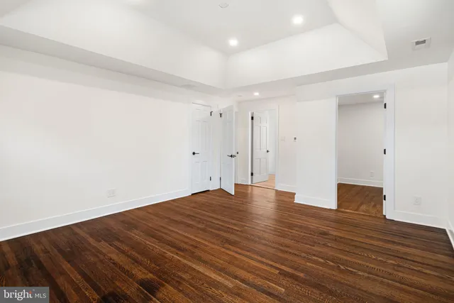a view of an empty room with wooden floor