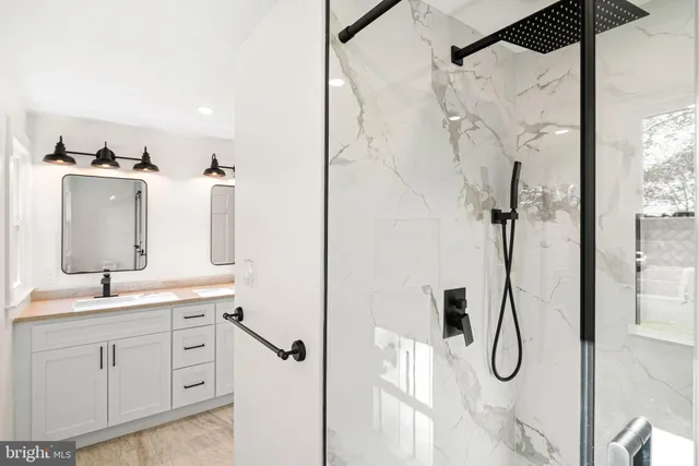 a en suite bathroom with a double vanity sink mirror and shower