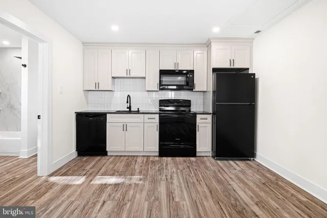 a kitchen with a refrigerator and a stove top oven