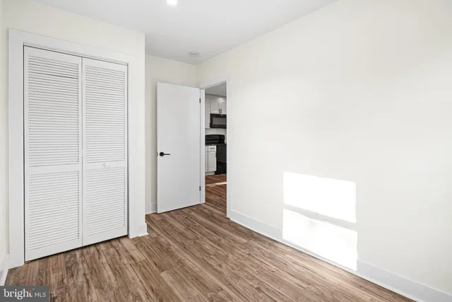 an empty room with wooden floor & windows