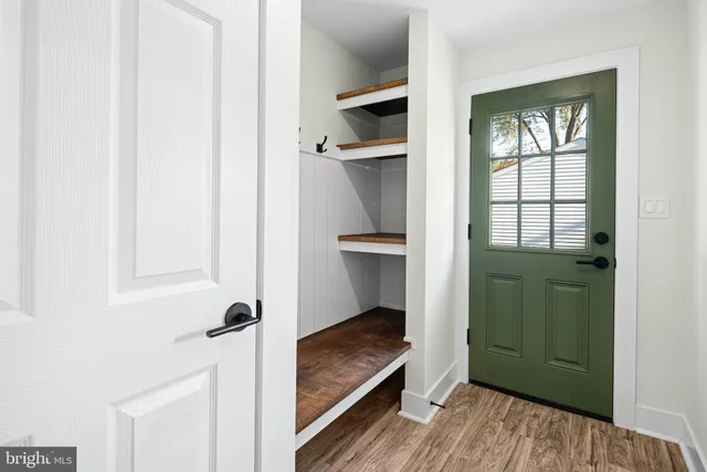 a view of an entryway with wooden floor and cabinet