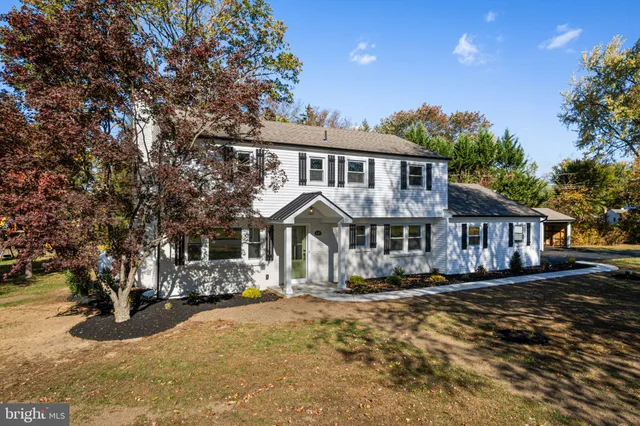 a front view of a house with a yard street and trees