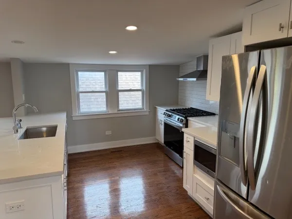 a kitchen with granite countertop a refrigerator and a sink