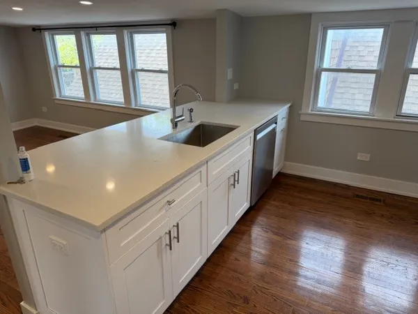 a kitchen with stainless steel appliances granite countertop a sink dishwasher a stove and a large refrigerator