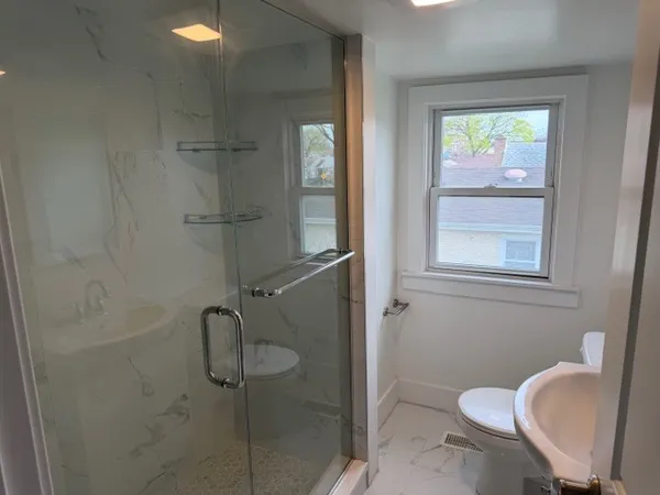 a bathroom with a sink toilet and shower