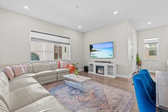 a living room with furniture two windows and a fireplace