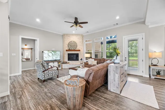 a living room with furniture a fireplace and a large window