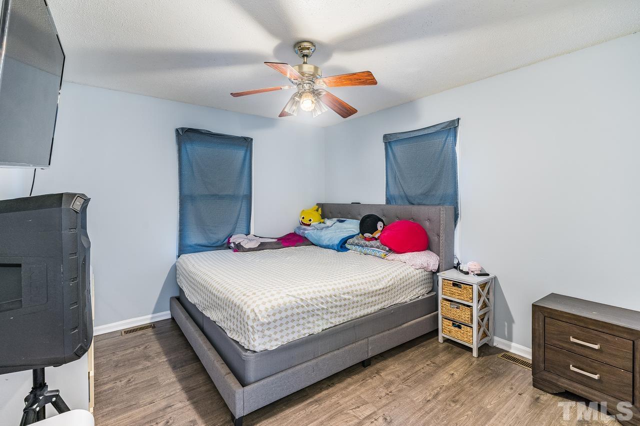 4557 Hargrove Road Raleigh, NC 27604 - Photo 11 of 16 a bedroom with a bed and wooden floor