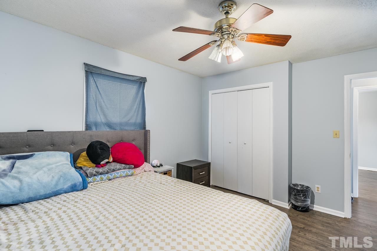 4557 Hargrove Road Raleigh, NC 27604 - Photo 12 of 16 a bedroom with a bed and a chandelier