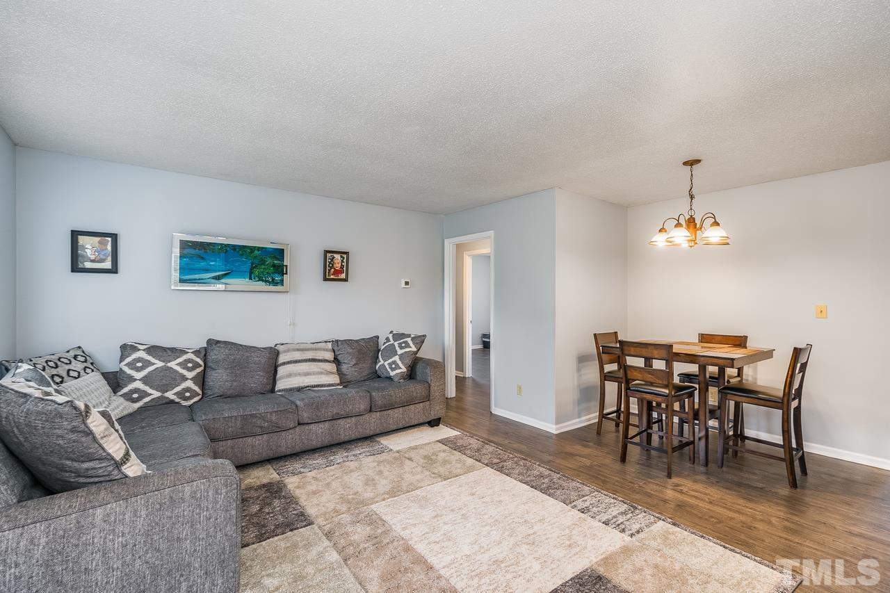 4557 Hargrove Road Raleigh, NC 27604 - Photo 5 of 16 a living room with furniture a dining table and a piano with wooden floor