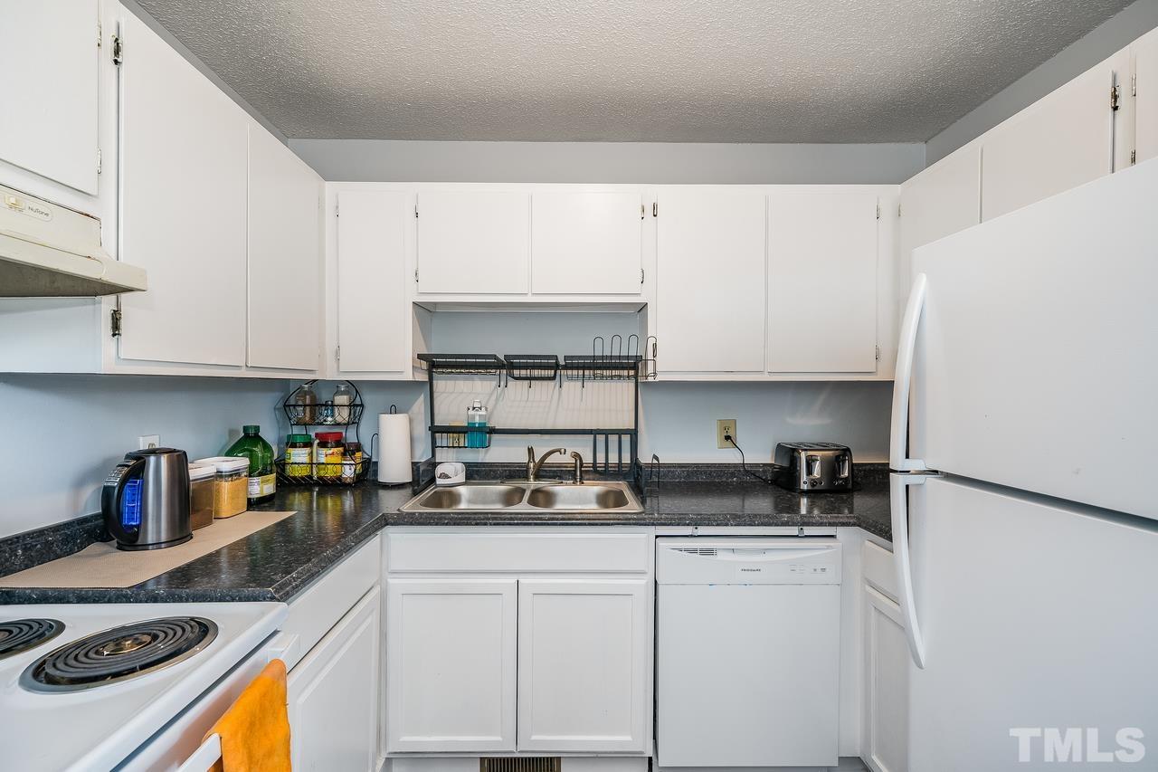 4557 Hargrove Road Raleigh, NC 27604 - Photo 10 of 16 a kitchen with stainless steel appliances granite countertop a sink stove and white cabinets