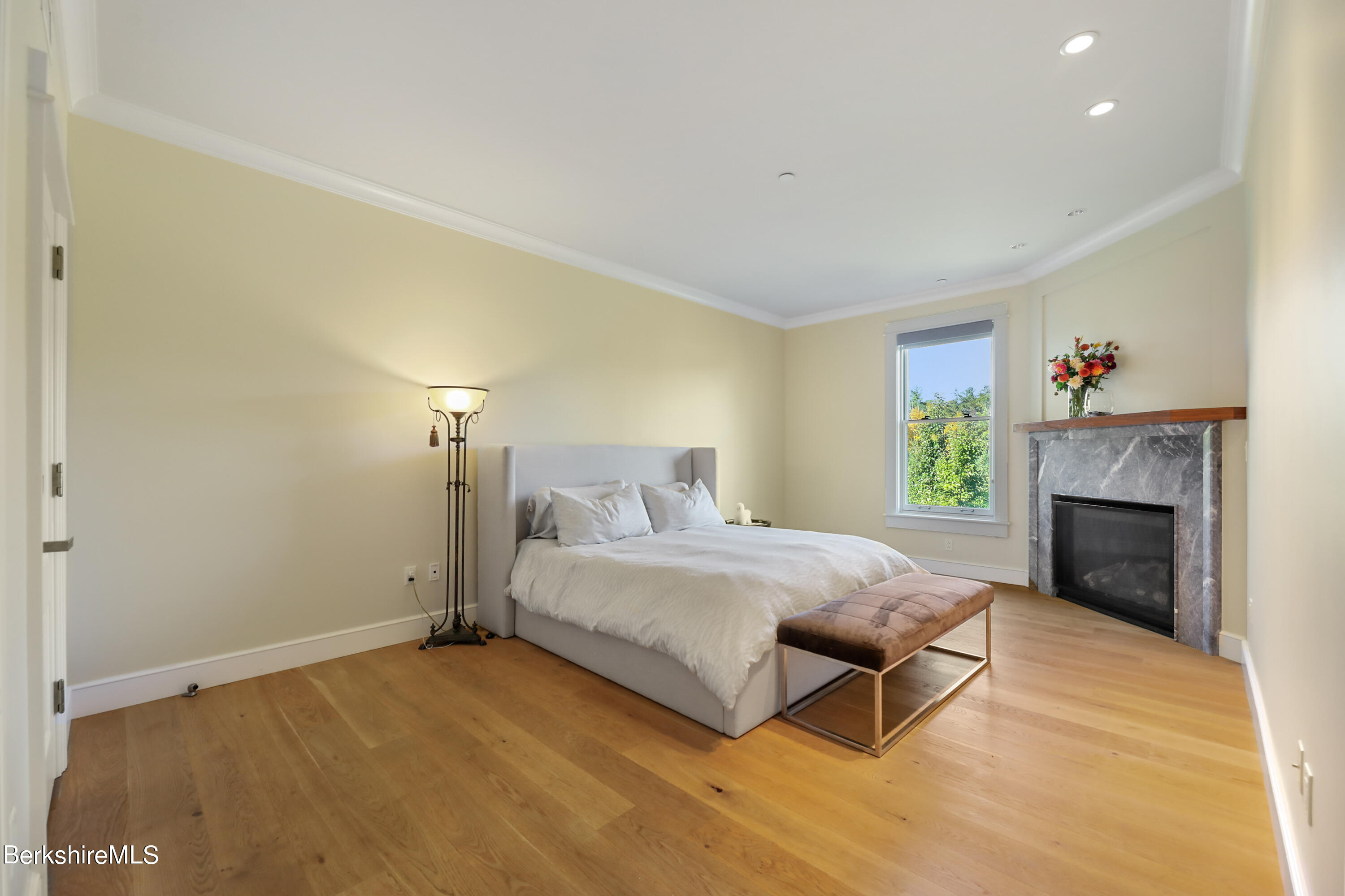 165 Kemble Street, Unit 16 Lenox, MA 01240 - Photo 16 of 31 a spacious bedroom with a bed and a fireplace