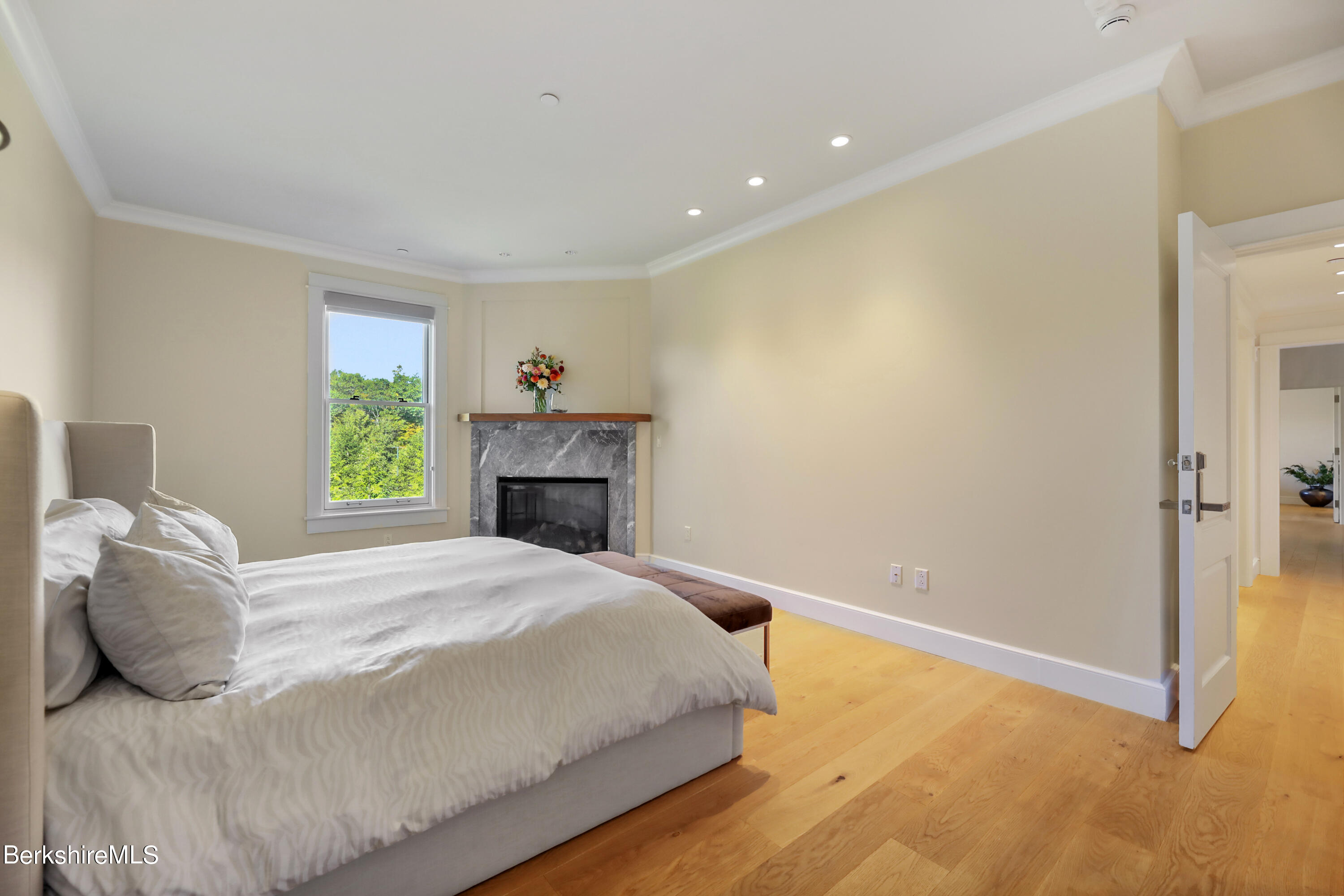 165 Kemble Street, Unit 16 Lenox, MA 01240 - Photo 17 of 31 a bedroom with a bed and a fireplace