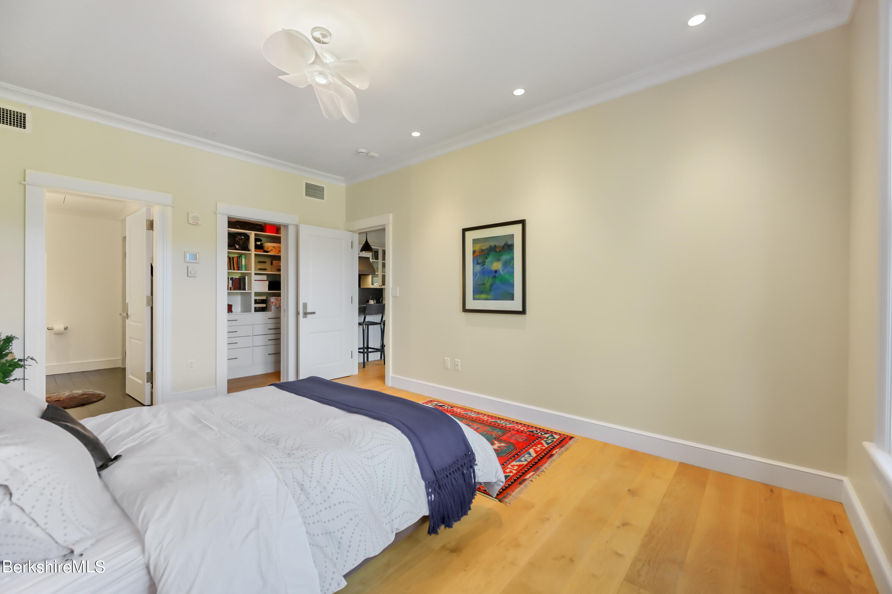 165 Kemble Street, Unit 16 Lenox, MA 01240 - Photo 22 of 31 a bedroom with a large bed and a chandelier