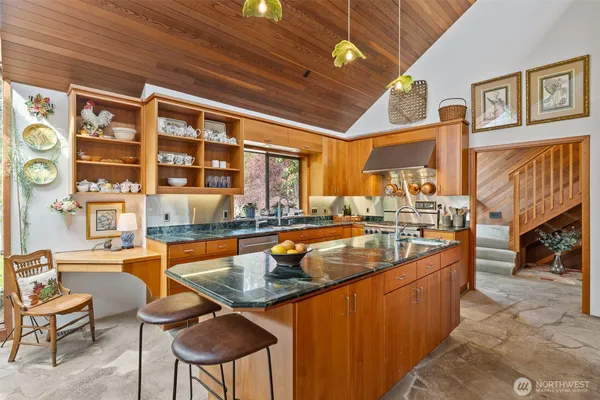 a dining hall with stainless steel appliances granite countertop a sink and a wooden floor