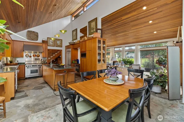 a dining room with stainless steel appliances kitchen island granite countertop furniture and a kitchen view