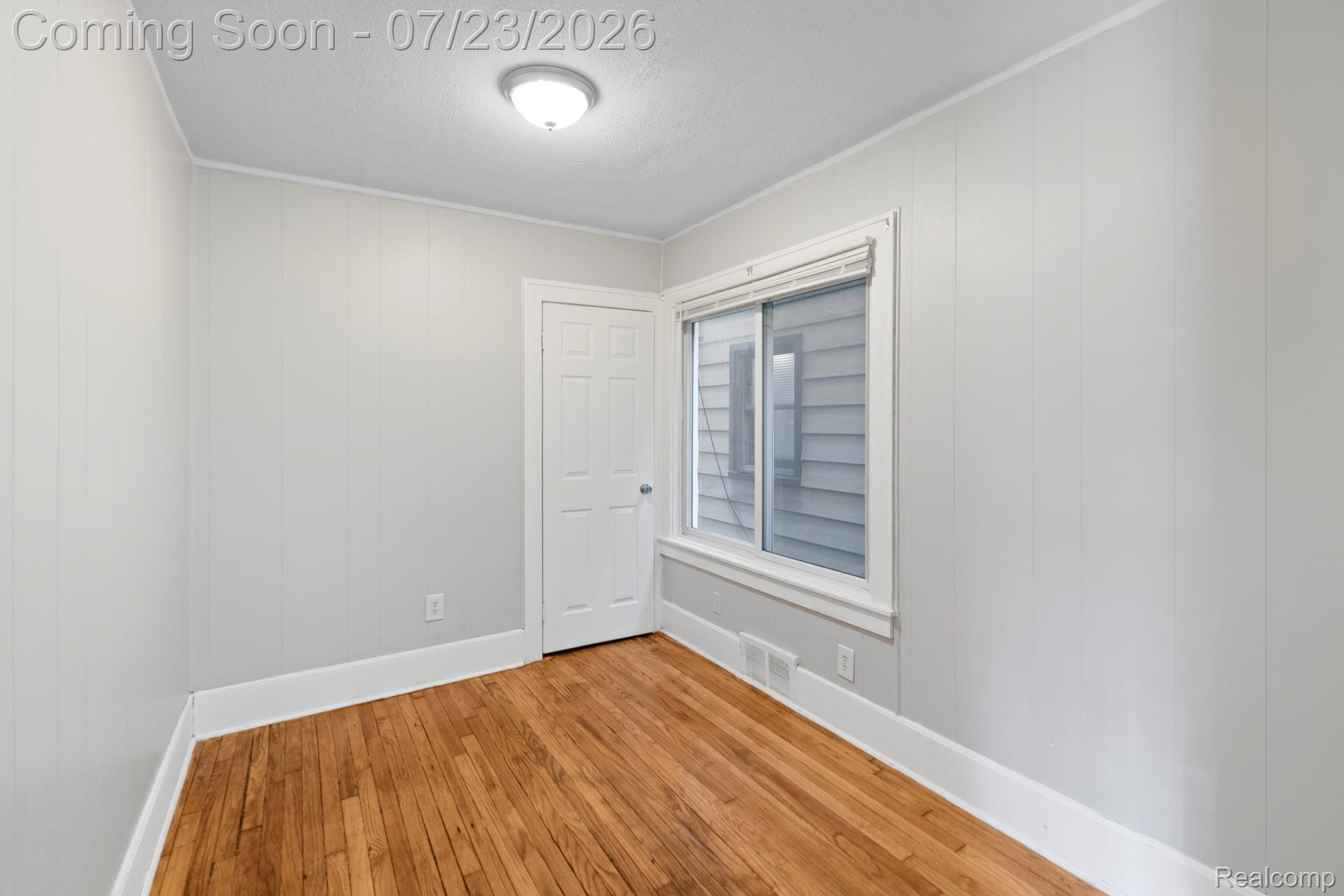 74 Pine Street River Rouge, MI 48218 - Photo 10 of 29 Empty room with light wood finished floors, a textured ceiling, and wooden walls