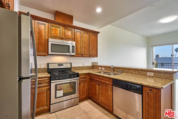 a kitchen with granite countertop a sink stove and microwave