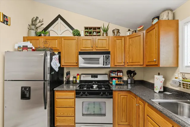 a kitchen with stainless steel appliances granite countertop a refrigerator a stove and a sink