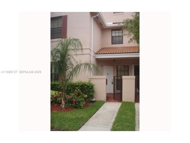 15875 Southwest 3rd Street, Unit 101 Pembroke Pines, FL 33027 - Photo 18 of 32 a view of a house with a small yard and floor to ceiling window